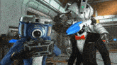 two robots with cameras on their heads are standing next to each other in a room