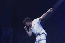 a man is standing on a stage with his arms outstretched .