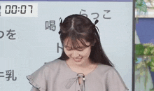 a young woman is smiling in front of a white board with chinese characters .