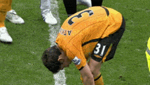a soccer player with the number 31 on his shorts looks down