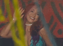 a woman with pink and purple hair is wearing a choker and a blue dress .