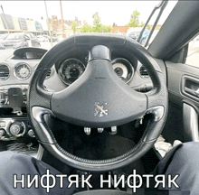 a steering wheel in a car with a peugeot logo