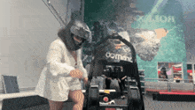 a woman wearing a helmet is standing next to a go kart