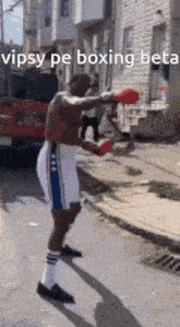 a man wearing boxing gloves is standing on a street with the words vipsy pe boxing beta written on the bottom
