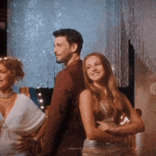 a man and a woman are standing next to each other and the woman is smiling and the man is looking at her