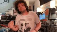 a man wearing a pink floyd shirt is dancing in front of a microphone