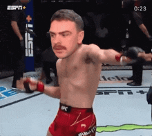 a man in a ufc shorts stands in front of a espn + sign