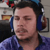 a man with a beard is wearing headphones and making a face .