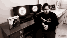 a person wearing a shirt that says the o is sitting in front of a computer