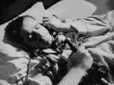 a black and white photo of a woman laying in bed