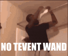 a man is hanging something from the ceiling with the words no tevent wand written below him