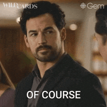 a man with a beard says " of course " in front of him