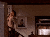 a woman standing on a staircase with a picture on the wall