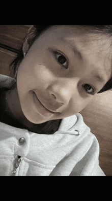 a close up of a girl 's face with a white shirt on