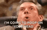 a man is sitting in a chair with his mouth open and says `` i 'm going to poop on your head `` .