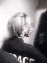 a blurry photo of a person wearing a black shirt that says peace on it .
