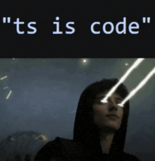 a man in a hoodie is looking at a screen that says ts is code