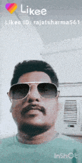 a man with a beard wearing sunglasses and a blue shirt