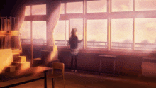 a girl standing in front of a large window looking out