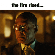 a man wearing glasses and a suit with the words " the fire rised " above him