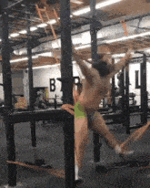 a man is hanging from a bar with the letter b on it