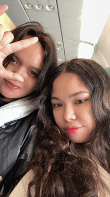 two girls are posing for a picture on an airplane