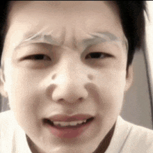 a close up of a person 's face with a piece of tape on their eyebrows