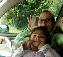 a woman and child in a car with a taxi sticker on the back door