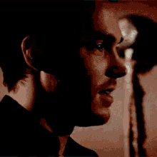 a close up of a man 's face with a beard and a black shirt .