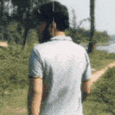 a man with a beard is standing in a field looking at the camera .