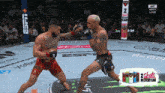 two men are fighting in a boxing ring with a 2 shots in every can advertisement