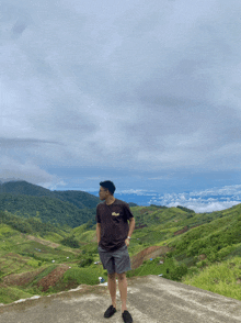 a man standing on top of a hill wearing a t-shirt that says ' abercrombie & fitch '