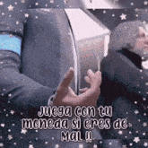 a man in a suit is holding a piece of paper that says " juega con tu moneda si eres de mal !! "