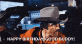 a man in a cowboy hat is driving a car and saying `` happy birthday , good buddy '' .