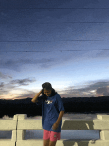 a person standing on a bridge wearing a t-shirt that says abercrombie