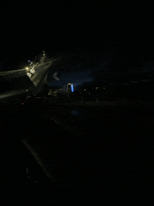 a dark night scene with a blue light on the right