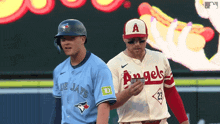 two baseball players wearing blue jays and angels jerseys