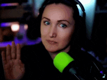 a woman wearing headphones and a green glowing item on her shoulder
