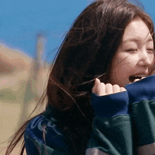 a woman wearing a green and blue striped sweatshirt with the word ucsd on it