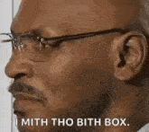 a close up of a man wearing glasses and a mustache saying `` i mith tho bith box '' .