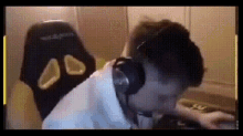 a man wearing headphones sits in front of a chair that says dxracer on it