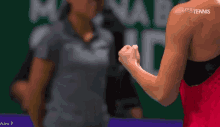 a woman in a red dress is holding her fist in the air