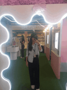 a woman taking a picture of herself in front of a sign that says life four cuts