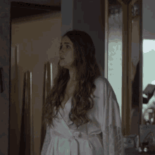 a woman with long hair wearing a white robe