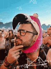 a man wearing glasses and a pink flamingo hat is surrounded by mathematical equations