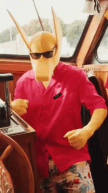a man wearing a mask and sunglasses is on a boat .