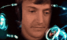 a close up of a man 's face with a screen behind him that says ' a ' on it