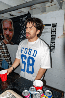 a man wearing a white ford shirt with the number 58
