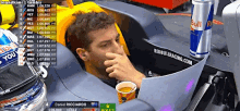 a man sitting in a race car with a can of red bull on the side