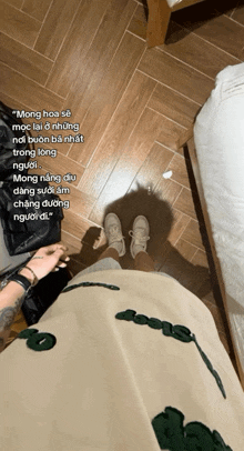 a person is standing on a wooden floor with a quote in a foreign language on the bottom
